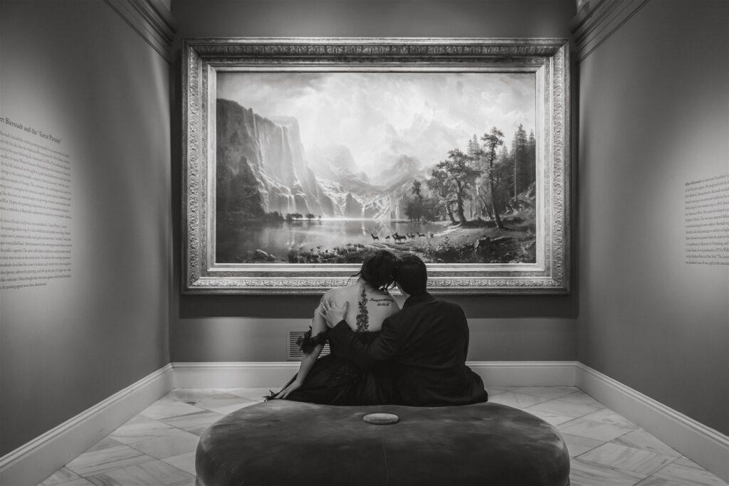 bride and groom sitting in front of a painting at the national portrait gallery 