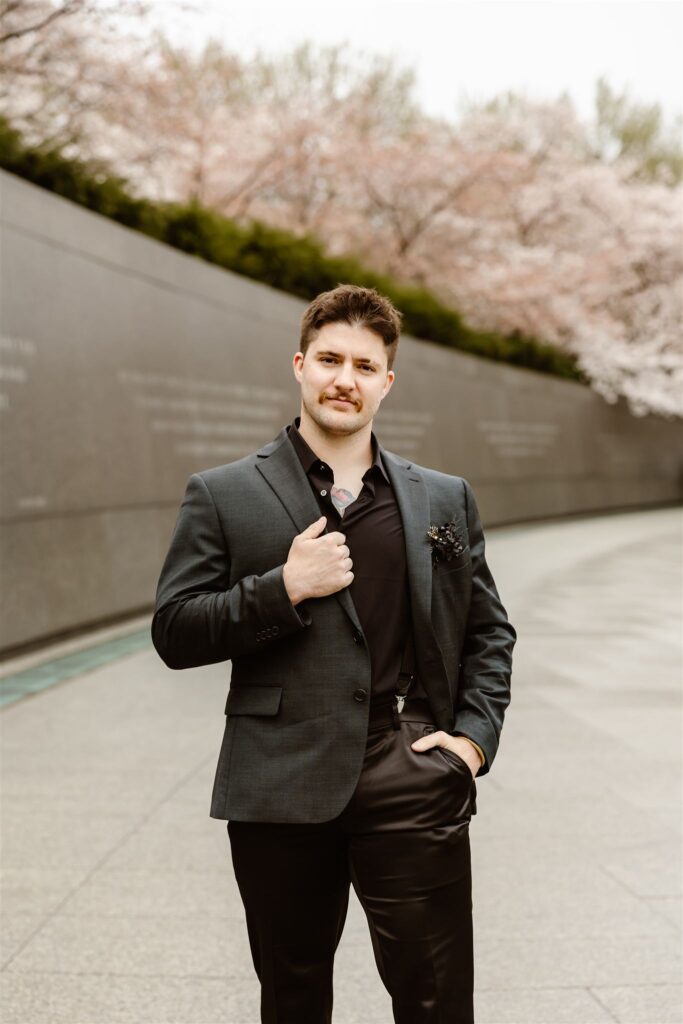 groom in a black suit during cherry blossom season at tidal basin