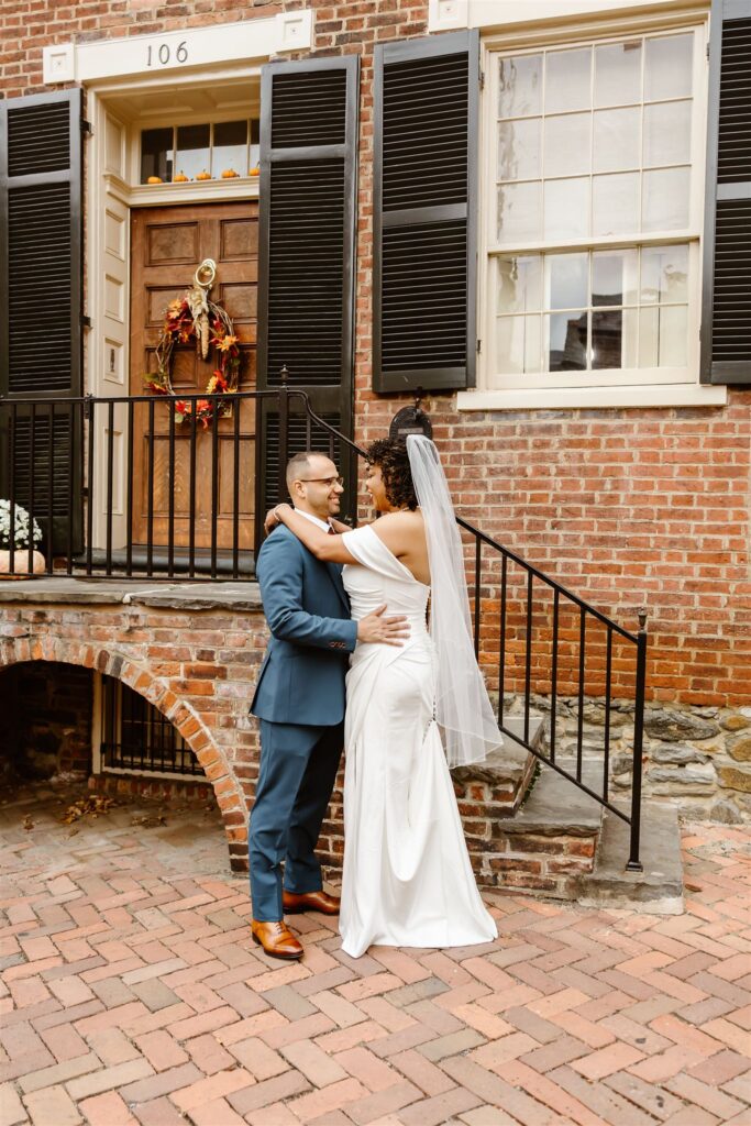 bride and groom hugging in a cobblestone street in Old Town Alexandria during their two day elopement 
