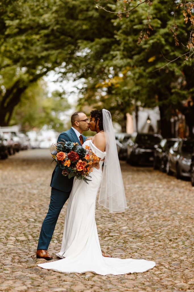 bride and groom kissing in a cobblestone street in Old Town Alexandria during their two day elopement 