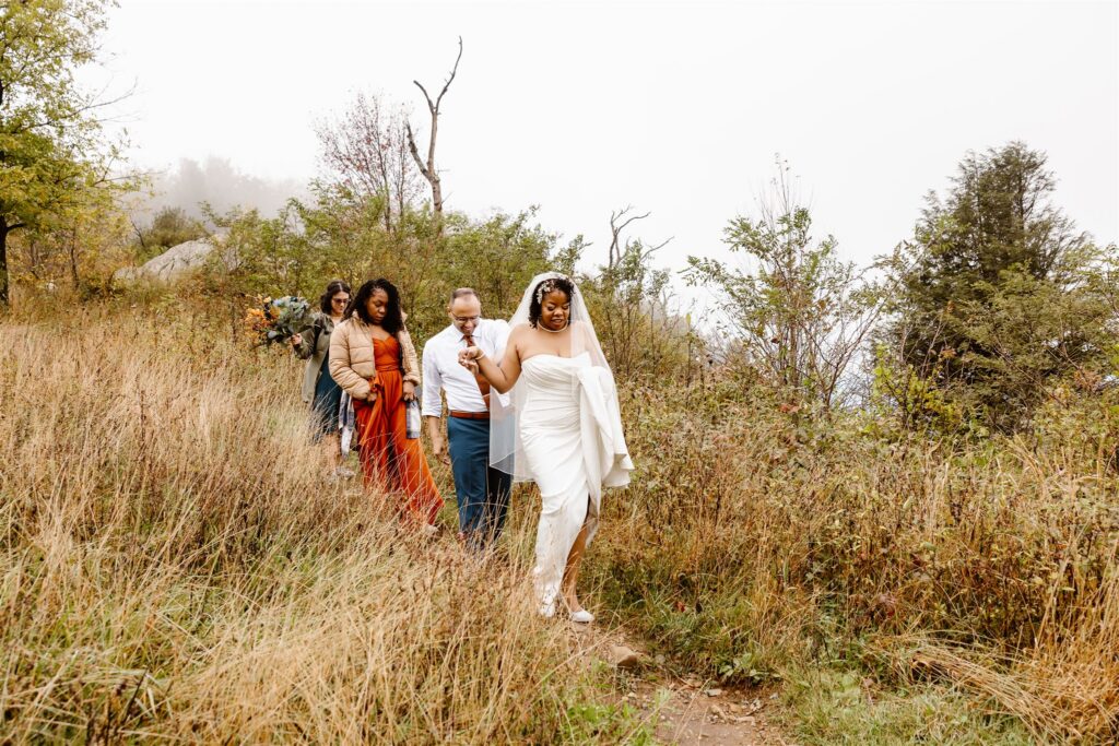 elopement couple and their loved ones hiking to their ceremony site in shenandoah national park