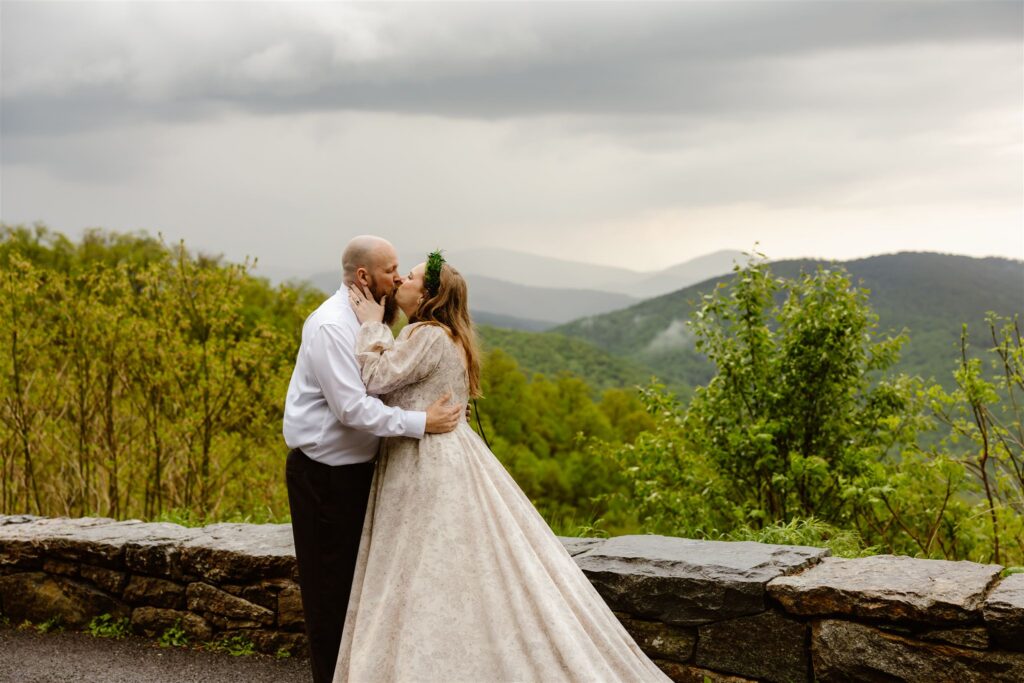 bride and groom kissing surrounded by moody mountain landscapes during their shenandoah national park elopement
