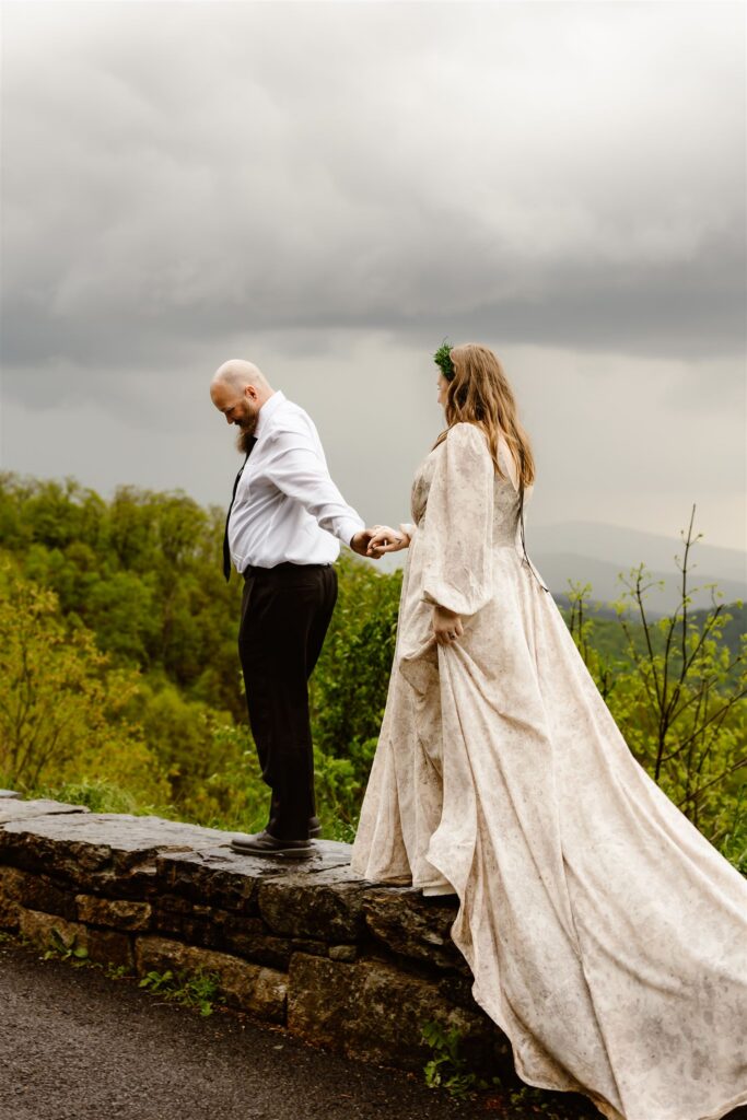 bride and groom holding hands as they are hiking together during shenandoah national park elopement