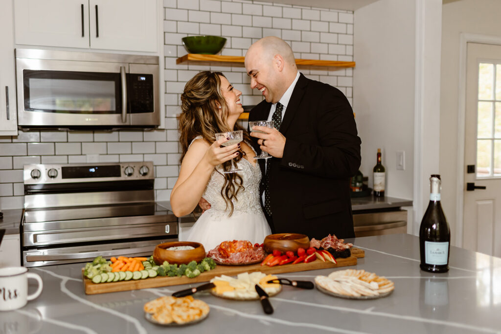 bride and groom sharing a charcuterie picnic at their airbnb