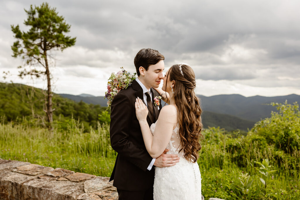 bride and groom snuggling at a mountain overlook in shenandoah national park