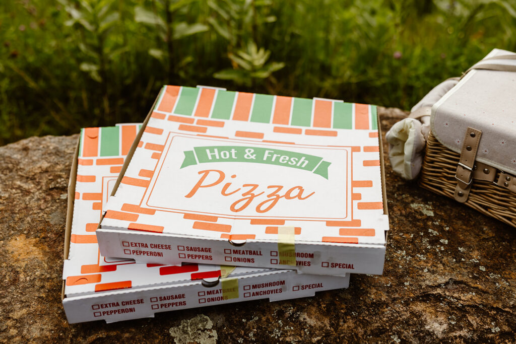 bride and groom eating pizza at a mountain overlook in shenandoah national park