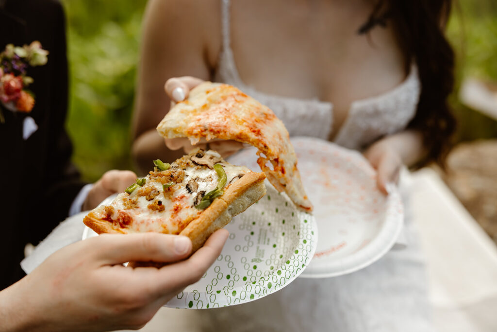bride and groom eating pizza at a mountain overlook in shenandoah national park