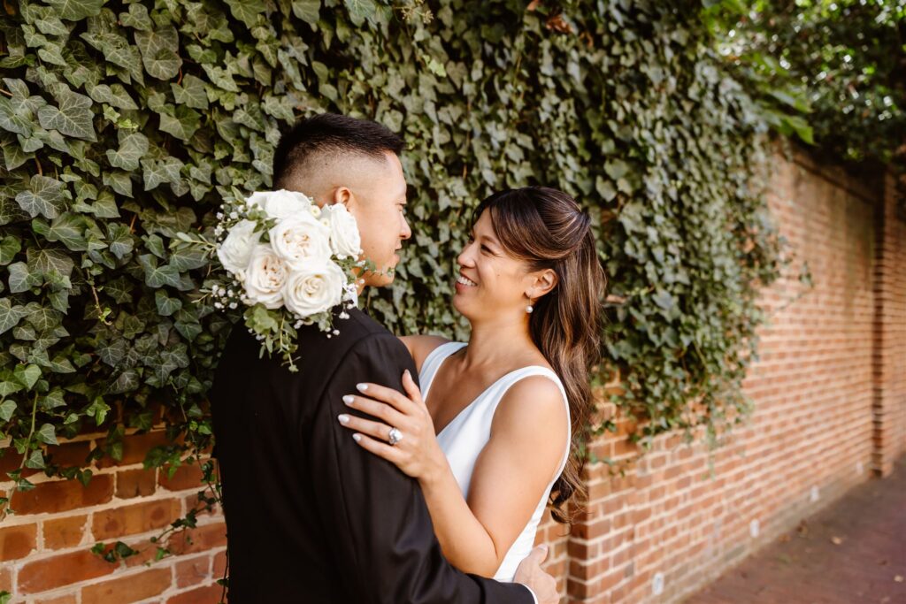 playful bride and groom hugging surrounded by the cobblestone streets of georgetown, dc