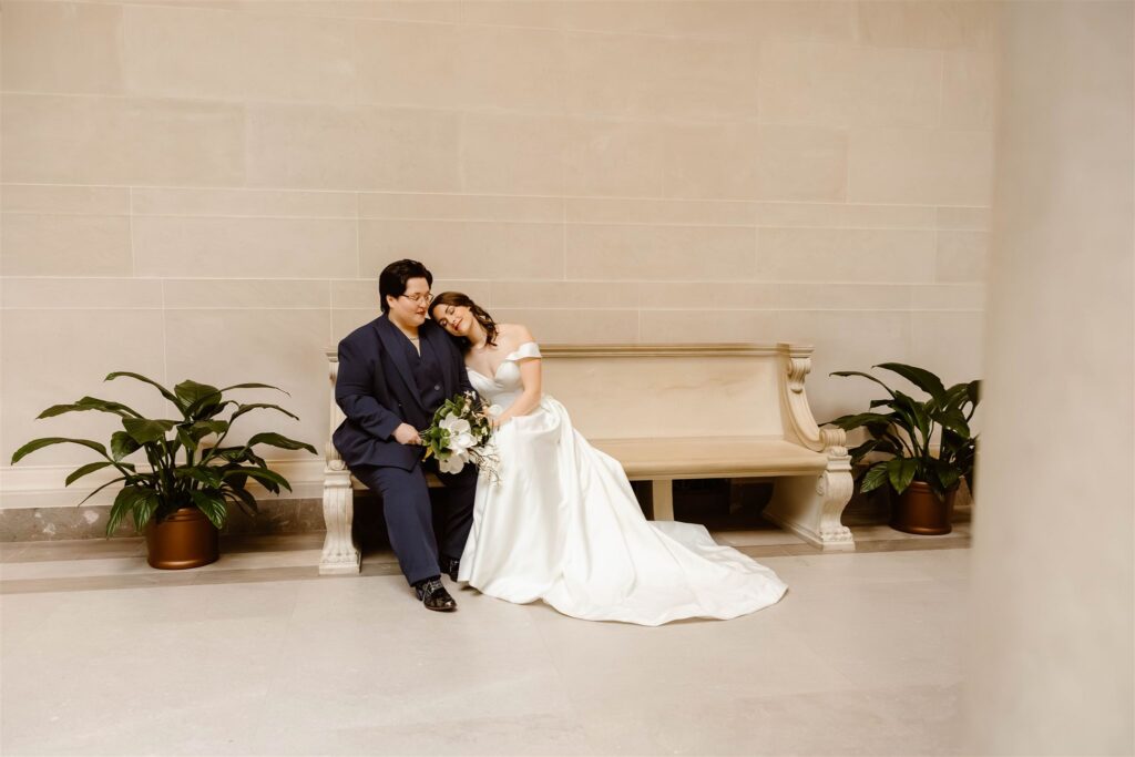 the wedding couple sitting on the benches at the National Gallery of Art
