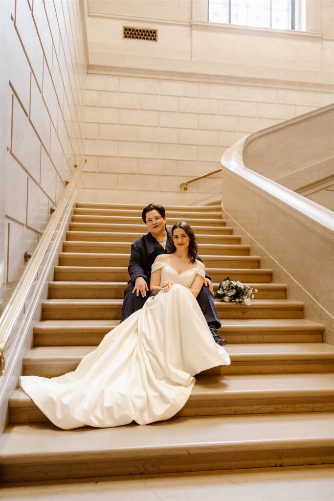 the wedding couple sitting on the stairs at the National Gallery of Art