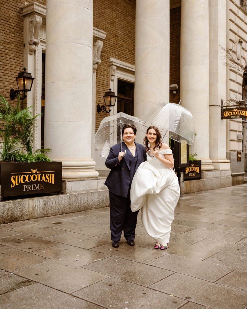 elopement couple under clear umbrellas in front of succotash prime