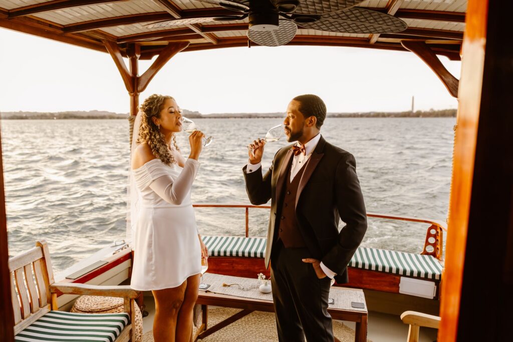 bride and groom sharing a champagne toast on the yacht floating on the potomac
