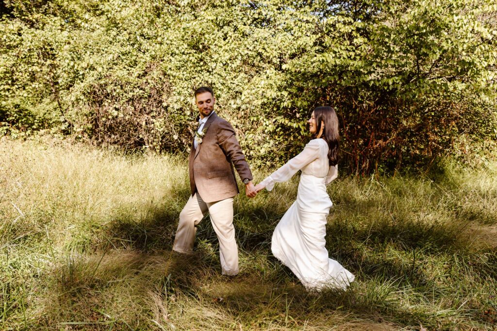 elopement couple walking in the meadow at the rock creek park