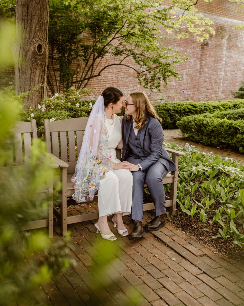 playful brides in a lush garden during their micro wedding in old town alexandria