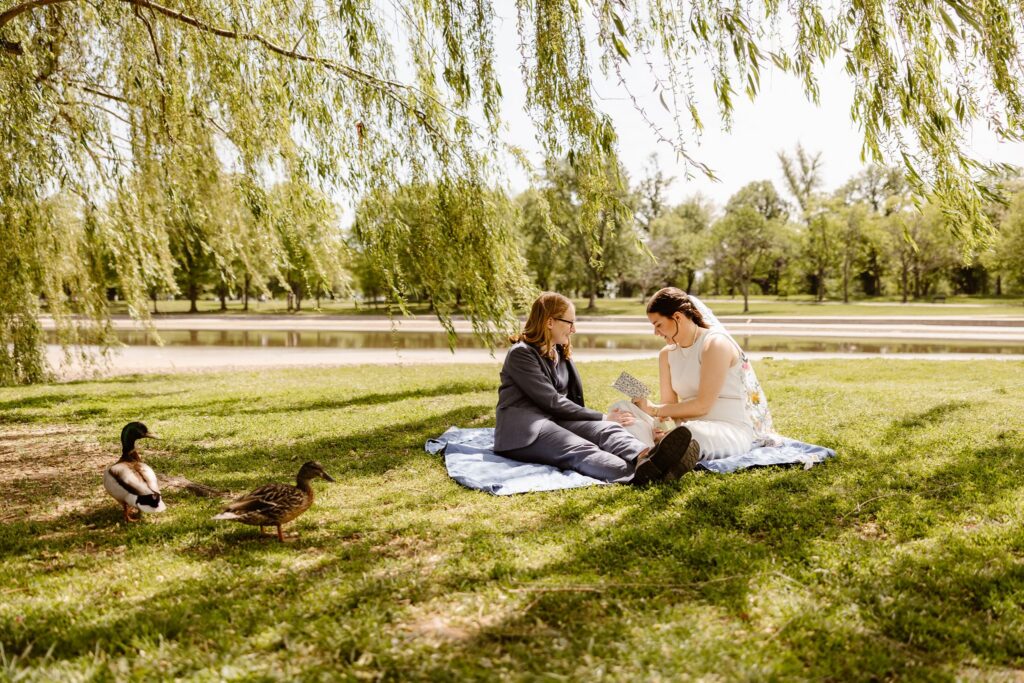 brides exchanging private vows while sitting on a blanket at constitution gardens in dc