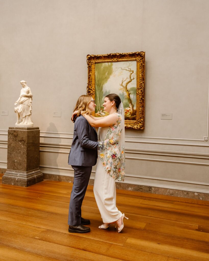 elopement couple hugging in front of artwork during their portraits at the national gallery of art in dc
