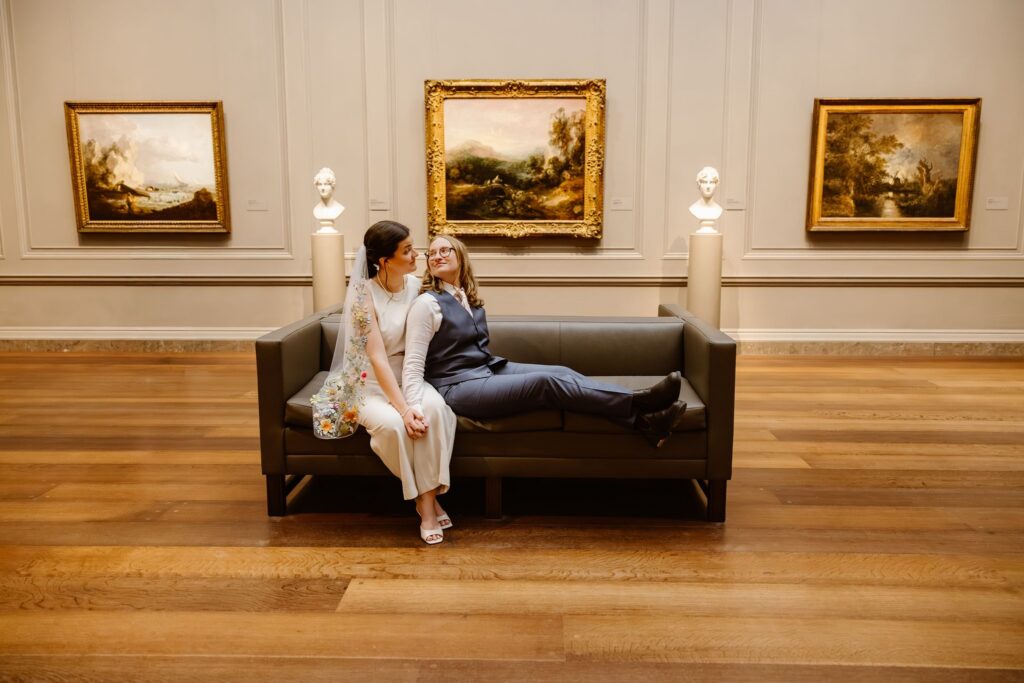 elopement couple sitting in front of artwork during their portraits at the national gallery of art in dc