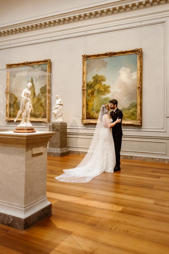 elopement couple hugging in front of artwork at the national gallery of art in dc