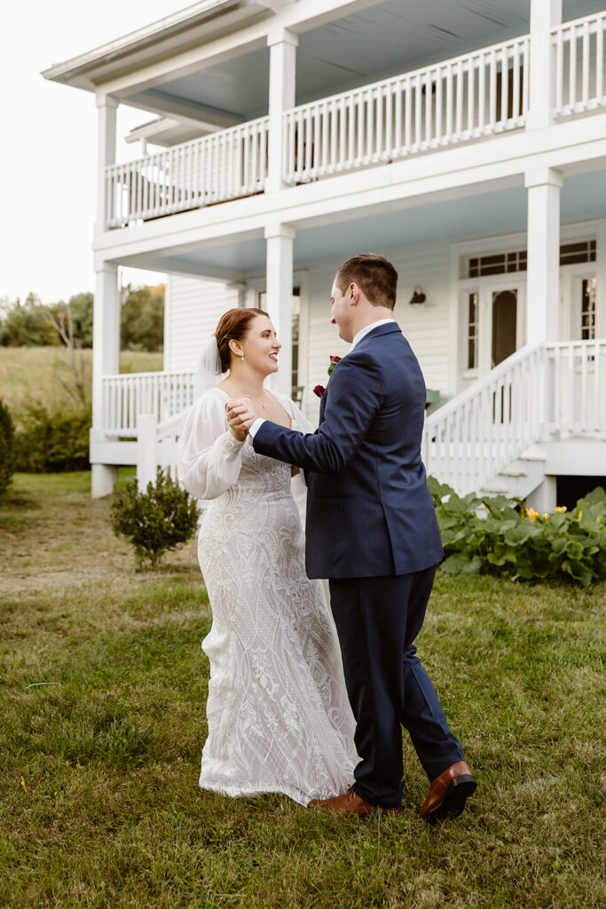 bride and groom first dance in front of the farmhouse vacation rental