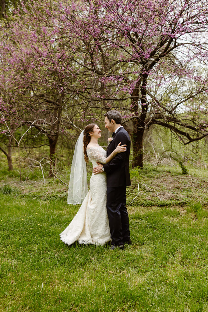 elopement couple hugging in front of a pink blossoming tree