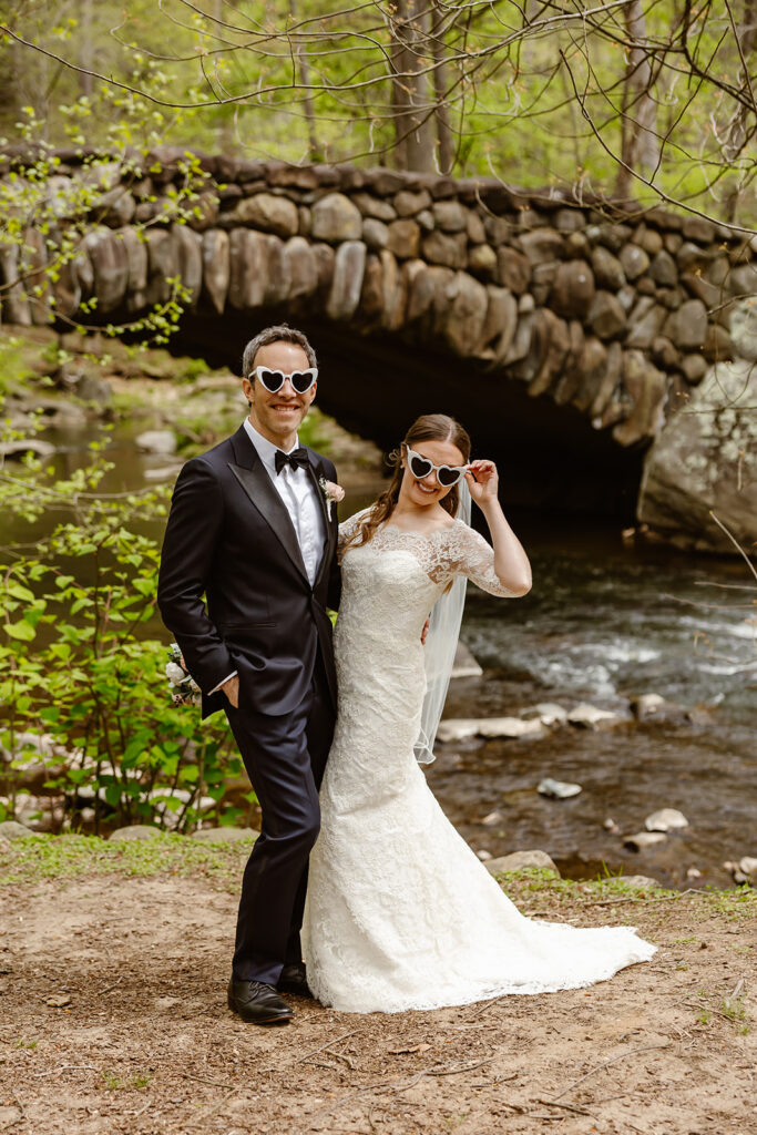joyful elopement couple at rock creek park posing in front of an old stone bridge